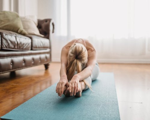 woman practicing yoga at home morning light